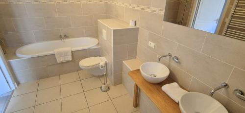 a bathroom with a sink and a toilet and a tub at La Grange - Gite Mur de Barrez in Mur-de-Barrez