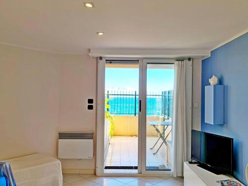 d'un salon avec une porte coulissante en verre s'ouvrant sur un balcon. dans l'établissement Mentone loft sul mare, à Menton