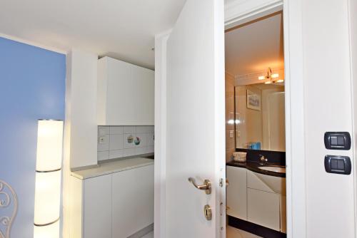 une cuisine avec des armoires blanches et un évier dans l'établissement Mentone loft sul mare, à Menton