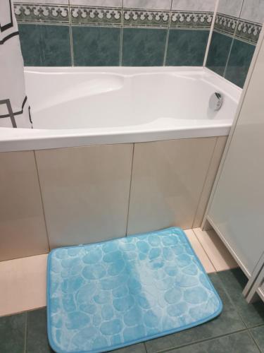 a bath tub with a blue mat underneath it at Queen Jadwiga's Apartment in Busko-Zdrój