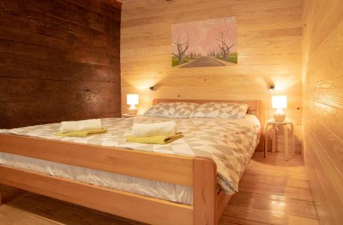 a bedroom with a large bed with wooden walls at Kuća za odmor Slunjčica in Slunj