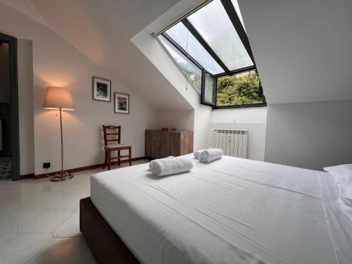 una camera da letto con un grande letto con due asciugamani di Mansarda Romantica a Rapallo
