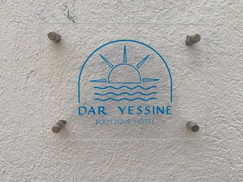 a sign on a wall with a boat in the water at Dar Yessine Boutique Hôtel in Sousse