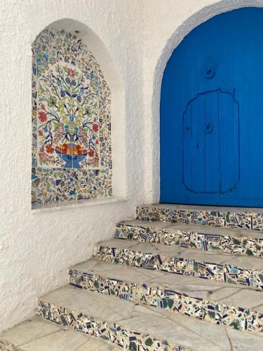 a staircase with a mosaic tile on the wall at Dar Yessine Boutique Hôtel in Sousse