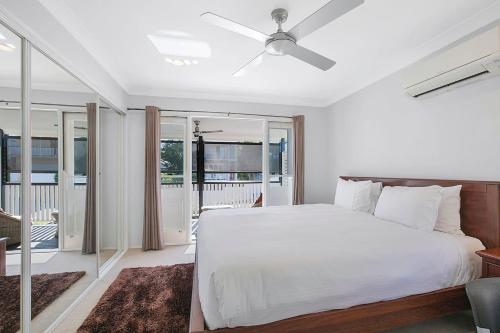 une chambre avec un lit blanc et un balcon dans l'établissement Paddington Cottage - A Classic Queenslander Stay, à Brisbane