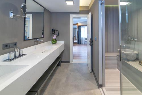 a bathroom with two sinks and a walk in shower at Deniz Boutique Hotel in Antalya