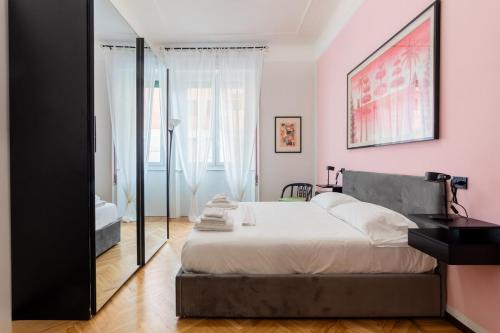 1 dormitorio con 1 cama grande y paredes de color rosa en Homeby - Appartamento Simonetta - Porta Romana en Milán