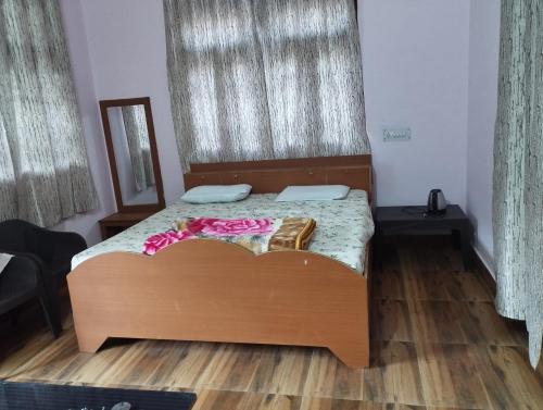 a bedroom with a bed with a wooden headboard at Rudhaare Homestay in Kausani