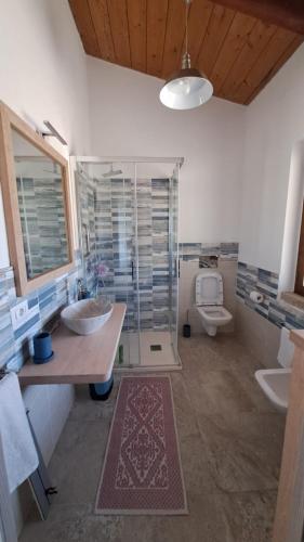 a bathroom with two sinks and a shower and a toilet at Villa DEA in Aglientu
