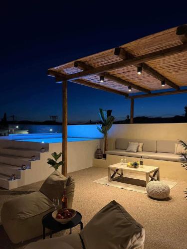 a patio with a couch and a table at night at Antheia Traditional House in Archangelos
