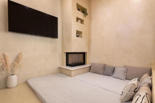 a living room with a couch and a flat screen tv at Antheia Traditional House in Archangelos