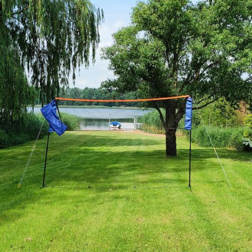a net in the middle of a yard with a tree at Przystań Nad Miążką in Sapowice
