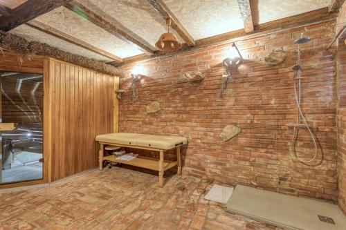 a bathroom with a brick wall with a shower at Bajsova domačija in Podčetrtek