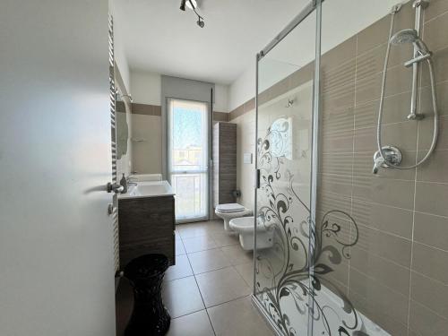 La salle de bains est pourvue de 2 toilettes et d'une douche en verre. dans l'établissement Homeby - Appartamento Barbara, à Milan