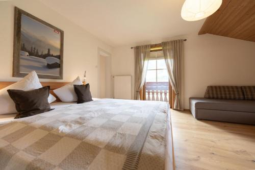 a bedroom with a large bed and a couch at Leindlhof in Kössen