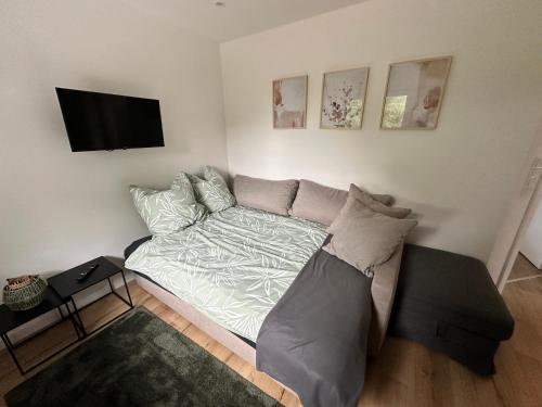 a bedroom with a bed and a flat screen tv at FeWo am Tillysee in Wardenburg in Wardenburg