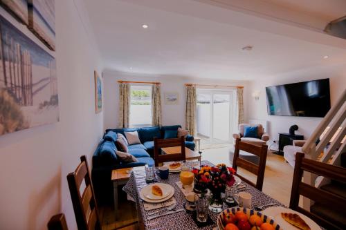 a living room with a table and a couch at St Anthony Cottage in Saint Mawes