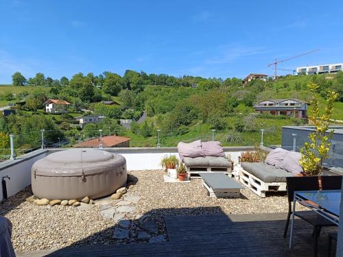 a patio with a hot tub and two couches on a roof at Plena naturaleza en Pleno San Sebastián in Donostia-San Sebastián