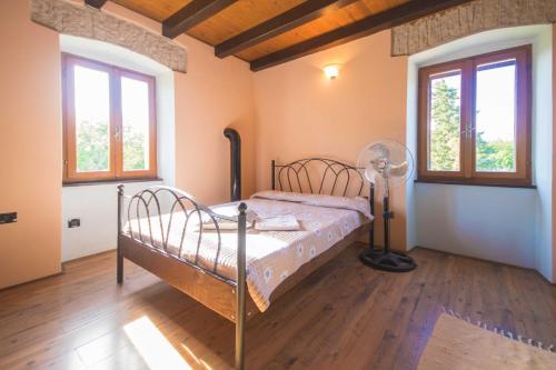 een slaapkamer met een bed in een kamer met ramen bij Villa Loreta, a beautiful and cozy villa minutes away from the sea in Raša
