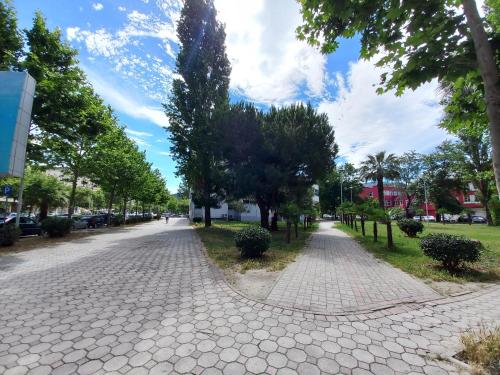 uma rua de calçada com árvores em ambos os lados em Studio al' PORTO em Vlorë