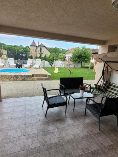 a patio with chairs and a table and a playground at Apartmani Apolon in Vrdnik