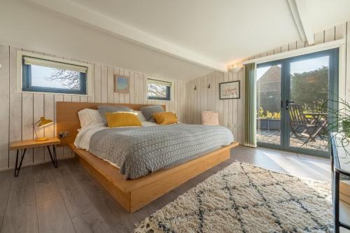 ein Schlafzimmer mit einem Bett und einem großen Fenster in der Unterkunft The Lavender Shack in Brooke