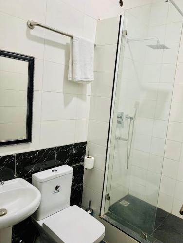 ein Bad mit einem WC und einer Glasdusche in der Unterkunft C to C luxury hotel in Enugu