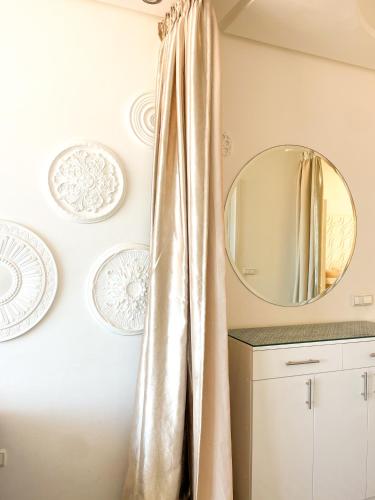 a bathroom with a gold shower curtain and a mirror at BIG BLUE guest house in Imsouane