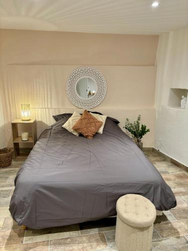 une chambre avec un grand lit avec un miroir au mur dans l'établissement Sweet home Kaysersberg, à Kaysersberg