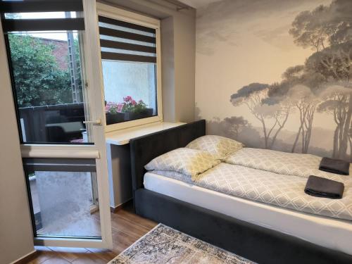 a bedroom with a bed and a window at Apartament 25 Mikołajki in Mikołajki