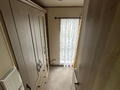 a hallway with a window with a curtain at Luxury Lake District Holiday Lodge-Sleeps 4 in Cockermouth