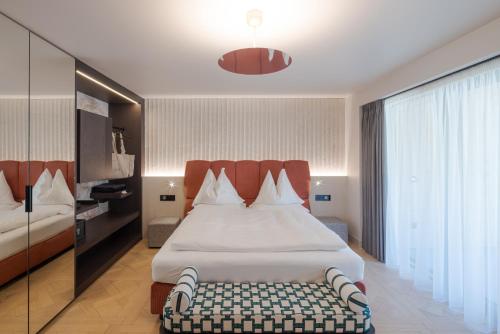 a hotel room with a bed and a large window at Latemar - Hotel Suites Spa in Soraga