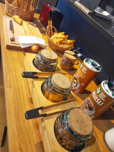 a buffet with jars of food and drinks on a table at Hôtel Restaurant L'Art des Mets by Côté Jardin in Conilhac-Corbières