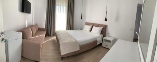 a hotel room with a bed and a couch at Villa Thomas in Dhërmi
