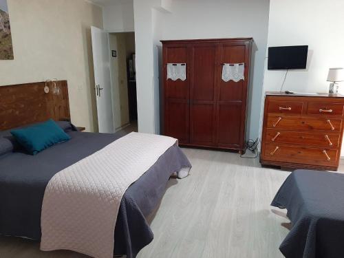 a bedroom with a bed and a dresser and a tv at Al Palmento in Galati Mamertino