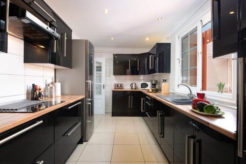 a kitchen with black cabinets and a counter top at Villa Naranja with private heated pool, sea views, air conditioning, terrace, ITV and BBC channels, Wifi in Callao Salvaje