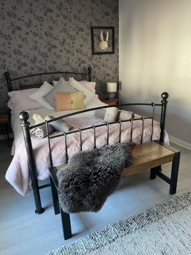 a bed with a black frame with a furry rug on it at The Salt house in Golspie