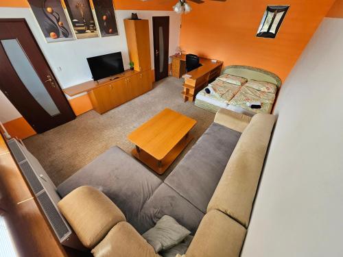 a living room with a couch and a table at WOLF APARTMAN Luxusné a ubytovanie s plnou výbavou s Bezplatným parkovaním Plochou TV a Optickým Internetom Priamo v Považskej Bystrici Tichá lokalita s Všade blízko Vhodné pre Jednotlivcov Rodiny Pracovné cesty Turistiku aj Oddych Plne vybavená Kuchyňa in Považská Bystrica