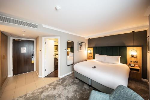 a hotel room with a large bed and a chair at Crowne Plaza London - Gatwick Airport by IHG in Crawley