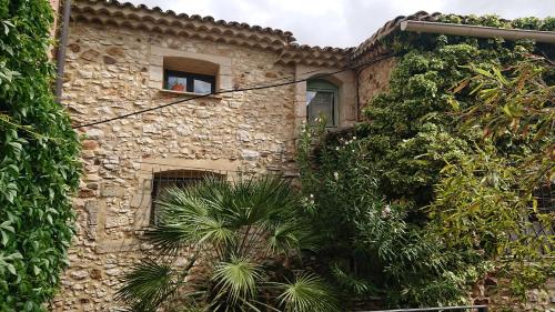 an old stone building with plants in front of it at Maison L'Authentique in La Capelle-et-Masmolène