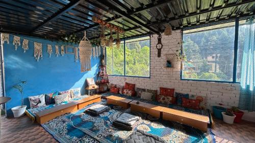 a living room with a couch and a blue wall at Kasolview Homestay and Peace Inn Cafe in Kasol