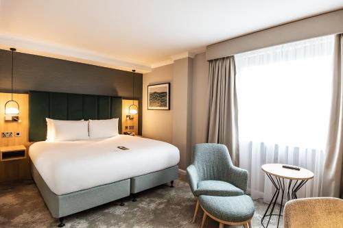 een hotelkamer met een bed en een stoel bij Crowne Plaza London - Gatwick Airport, an IHG Hotel in Crawley