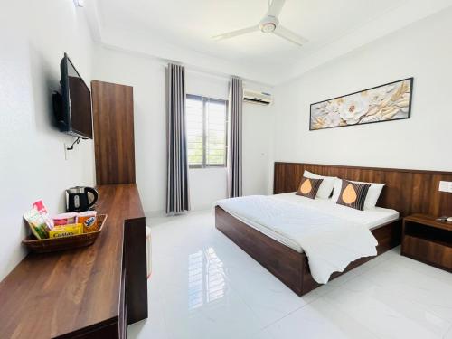 1 dormitorio con 1 cama y TV de pantalla plana en KL Retreat Hotel, en Thanh Hóa