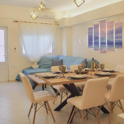 a dining room table with chairs and a blue couch at DA Sea Breeze next to the sea in Faraí