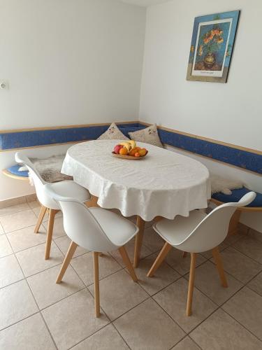 a table with chairs and a plate of fruit on it at Hiška na gorci in Podčetrtek