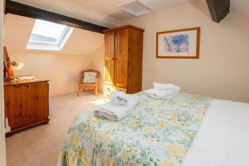 a bedroom with a bed with two towels on it at Myrtle Cottage in Chapel Stile