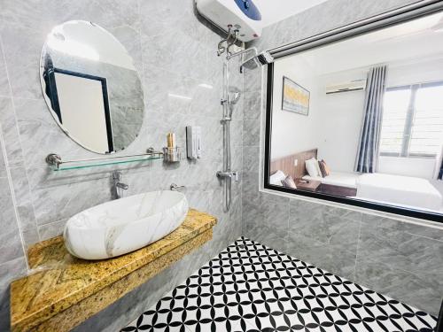 łazienka z dużym lustrem i umywalką w obiekcie KL Retreat Hotel w mieście Thanh Hóa