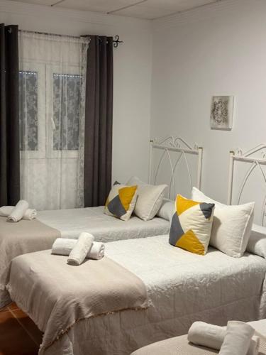 a room with two beds with pillows on them at Hostal Paquito in Vejer de la Frontera