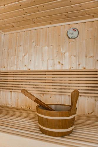 a wooden bucket in a room with a clock on the wall at 't Valkennest in Zwalm