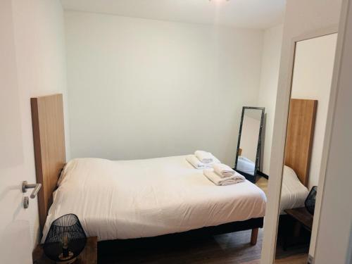 um pequeno quarto com uma cama e um espelho em KOSY Appart'Hôtel 7ème Art em Saint-Avold
